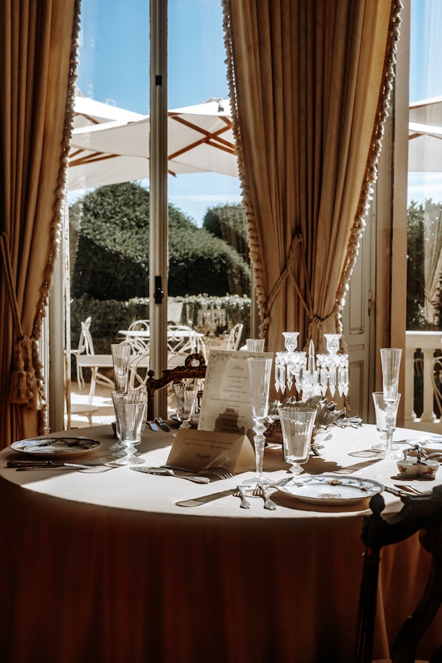 A candlelit wedding table set beside a sunlit garden window